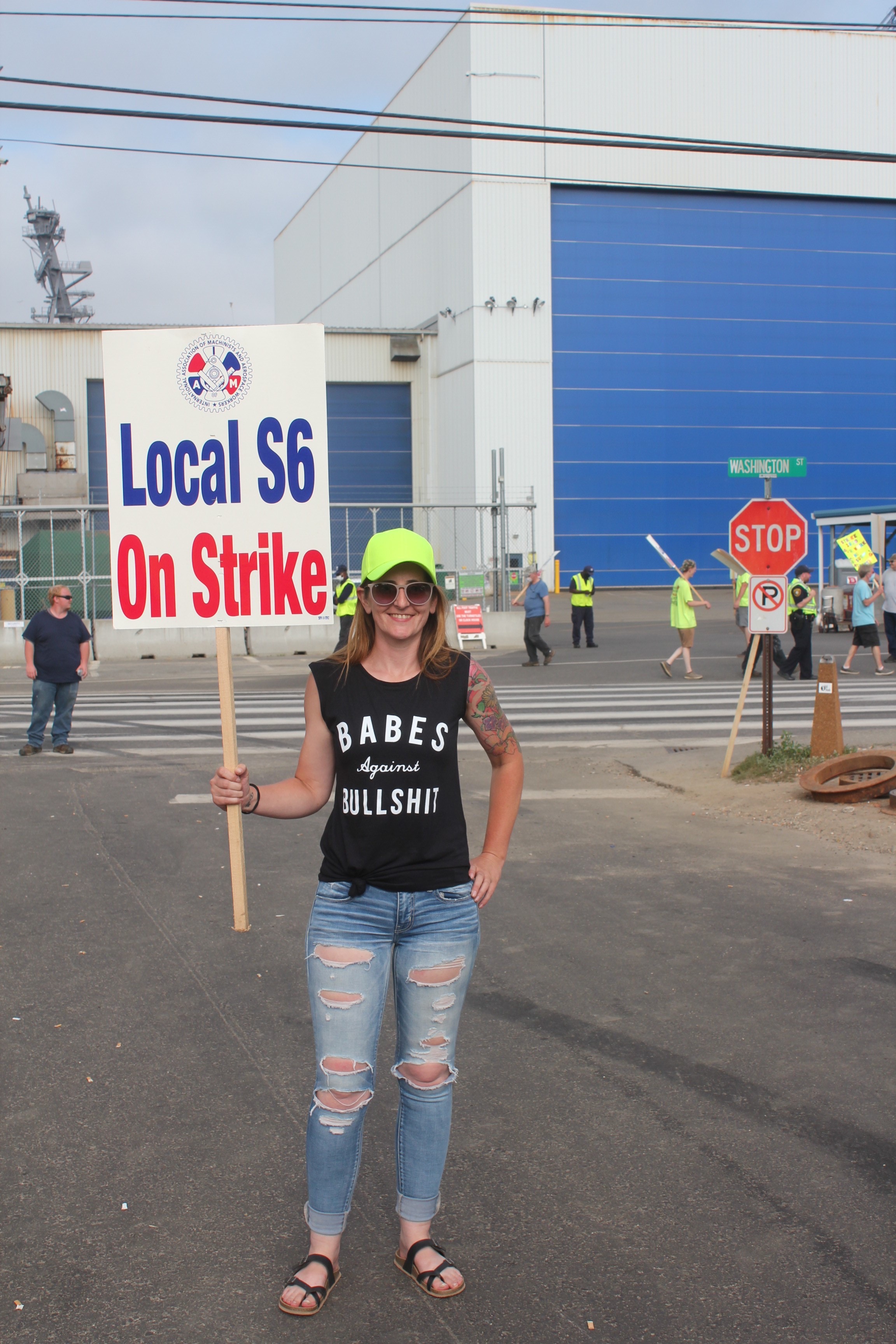 Jami holds a 'Local S6 on strike' sign; her shirt says 'Babes against bullshit'