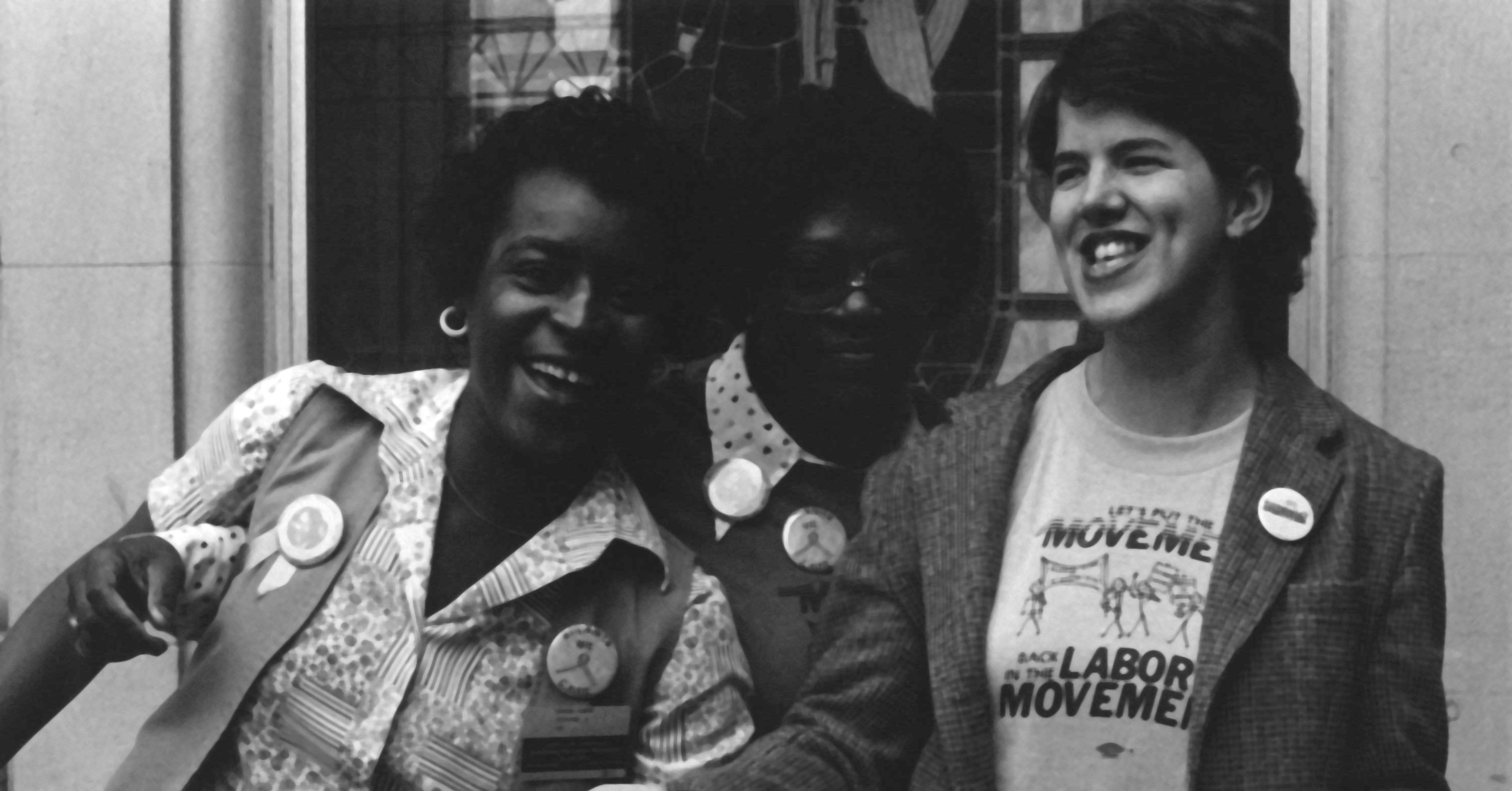 Multiracial group of activists standing next to each other and laughing.