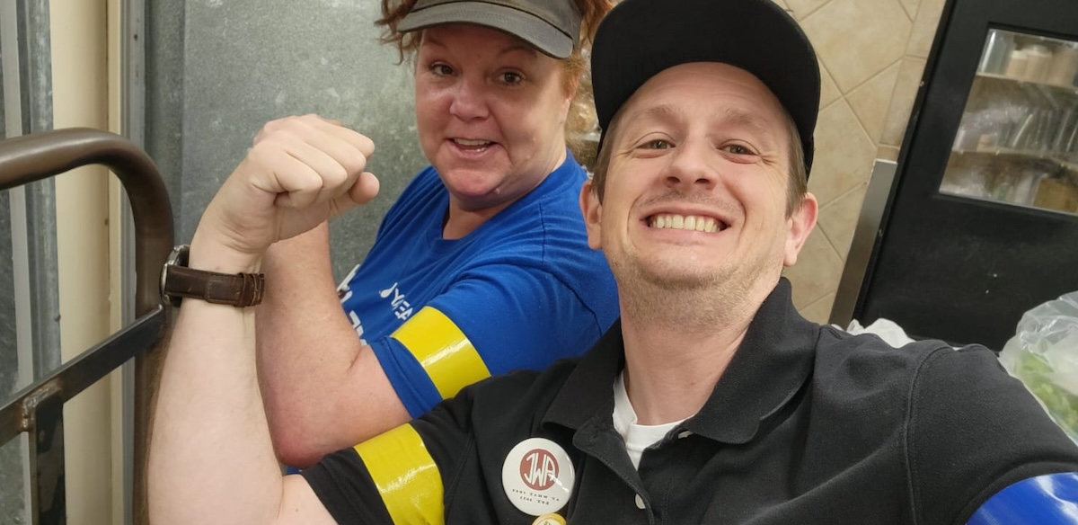 A man and a woman hold up fists