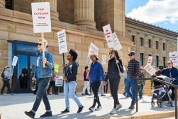 Strikers and supporters march with picket signs in front of the Philadelphia Museum of Art.