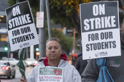 A white man and a Black man hold signs: "On Strike for Our Students; UTLA"