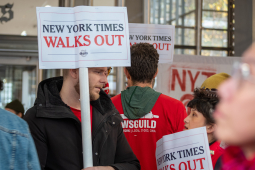 picketers outside New York Times headquarters with a jumble of NewsGuild signs.