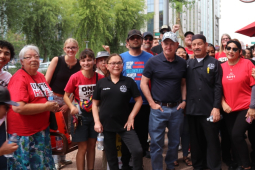 A group 25 of workers in red shirts gather near an umbrella saying Panda Express