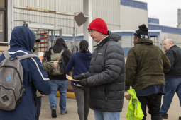 Candidate Shawn Fain passes out leaflets to several workers entering parts plant