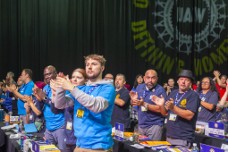 Delegates stand and applaud at the UAW convention.