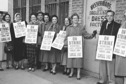 A group of striking garment workers stand in front of their factory in 1958.