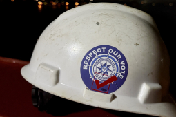 A white hardhat with a sticker that reads "Respect Our Vote."