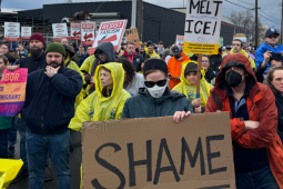 Workers gather in a March 27 protest holding signs reading "Shame" and "Melt ICE!"
