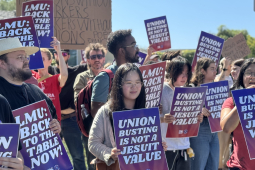 Students and faculty members rally holding signs that say "Union Busting Is Not a Jesuit Value" and "LMU: Back to the Table Now."