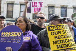 Several demonstrators gather with various signs about Medicaid and Social Security