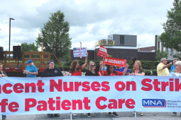 People outside hold a huge banner: "St. Vincent Nurses on Strike for Safe Patient Care; MNA"