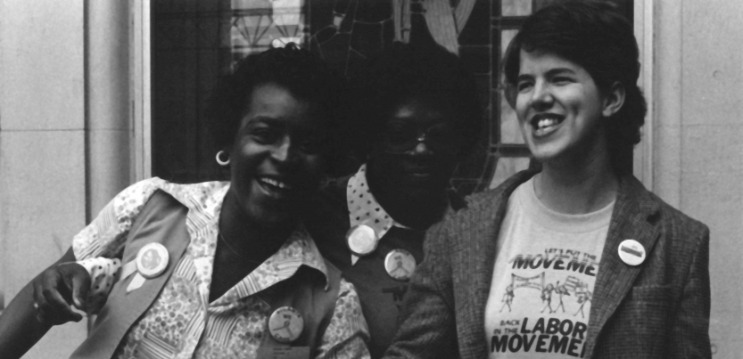 Multiracial group of activists standing next to each other and laughing.