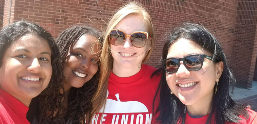 Selfie of four Baltimore teachers in front of a school.