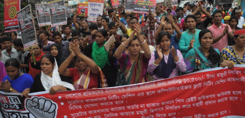 Bangladeshi workers rally behind a banner