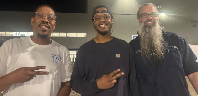 Three workers who served as election observers for the union pose for a photo, with their hands giving peace signs.
