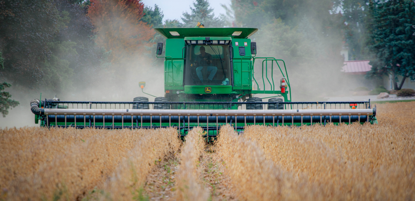 A worker drives a tractor through a field.