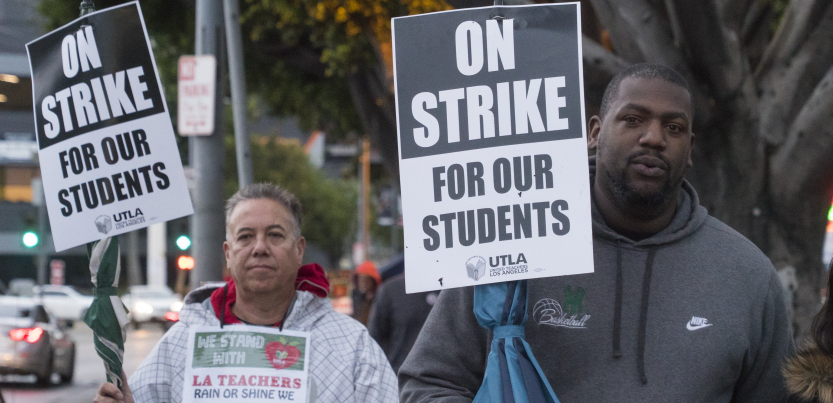 A white man and a Black man hold signs: "On Strike for Our Students; UTLA"
