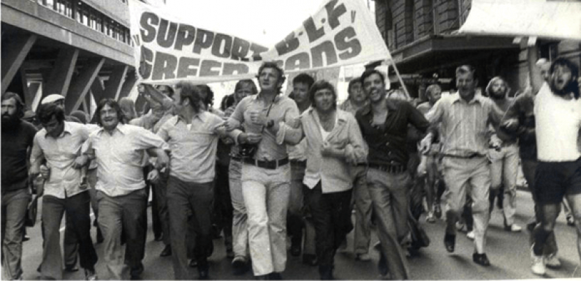 Black and white photo of men marching with a banner: "SUPPORT BLF GREEN BANS"
