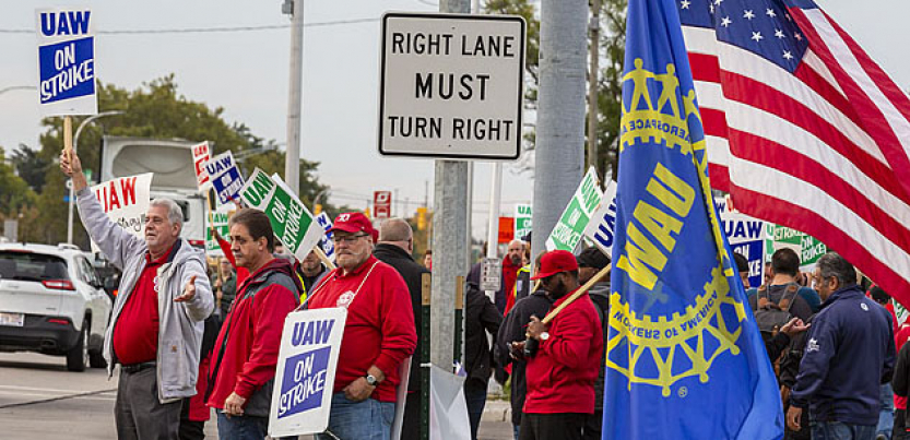 Des grévistes de l’UAW font du piquetage au coin d’une rue.