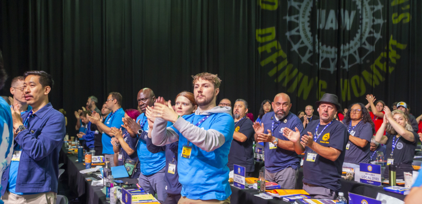 Delegates stand and applaud at the UAW convention.
