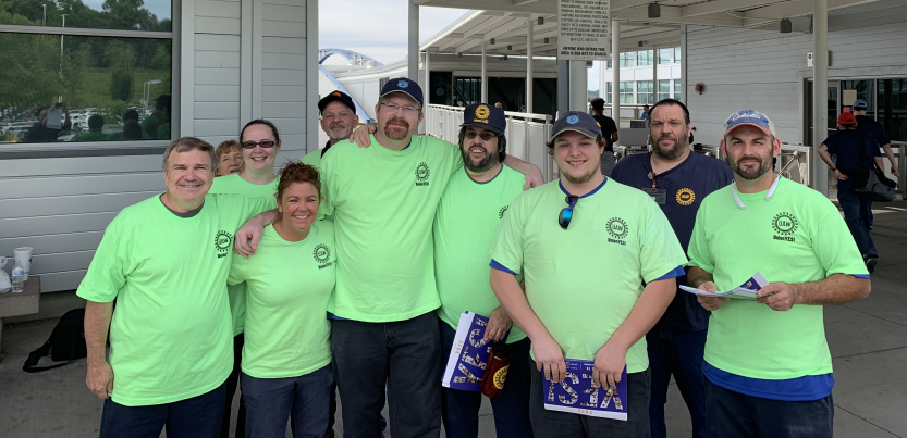 Group of workers in matching green T-shirts outside the plant