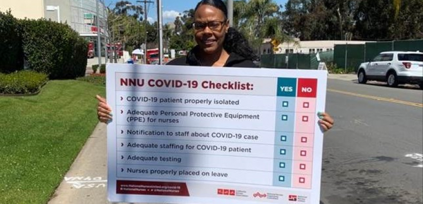 A nurse holds a sign showing "NNU COVID-19 Checklist: patient properly isolated, adequate PPE for nurses, notification to staff about case, adequate staffing for patient, adequate testing, nurses properly placed on leave"