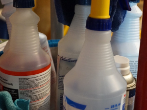 A closeup of bottles of cleaner in a custodial cart.