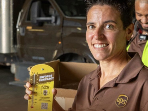 A woman in UPS brown uniform holds up a thermometer