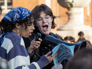 two young people address a crowd in what appears to be a campus setting