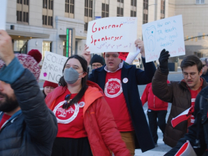 A crowd marches with signs