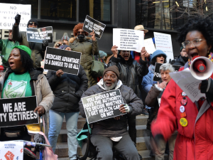 A group of retirees protest with signs saying Medicare Advantage is a Danger to Us All