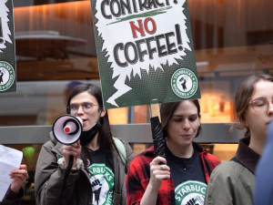 workers march with “no contract, no coffee” signs, one with a megaphone