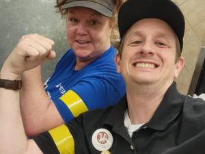 A man and a woman hold up fists