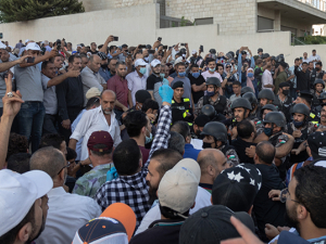 Crowd of teachers and supporters protesting in Amman in front of building, some with raised arms, on July 29 2020