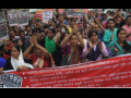 Bangladeshi workers rally behind a banner