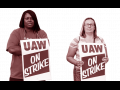Two UAW workers with picket signs