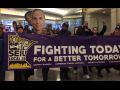 Commercial office janitors, retail janitors, security officers, window cleaners, and airport workers march through the downtown Minneapolis skyway, carrying a banner that reads "Fighting Today for a Better Tomorrow," as part of SEIU Local 26's contract campaign.