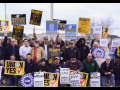 A crowd with signs saying "Millwrights Local 1554 support UAWVW workers," "IUPAT Local 226 supports UAWVW workers," "Solidarity," "Union Yes," "Ver.di," "UAW"