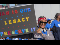 Woman auto worker holding up sign