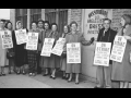 A group of striking garment workers stand in front of their factory in 1958.