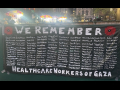 A black banner with white letters lists 160 health care workers killed in Gaza. It is titled “We Remember”.