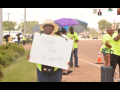 A woman holds a sign reading Hold the Line while others stand on the picket line.