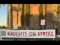 Strikers stand in front of Medieval Times holding a banner that reads "Knights on Strike."