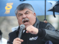 Richard Trumka speaking animatedly into a microphone, under an umbrella, at a 2016 demonstration.