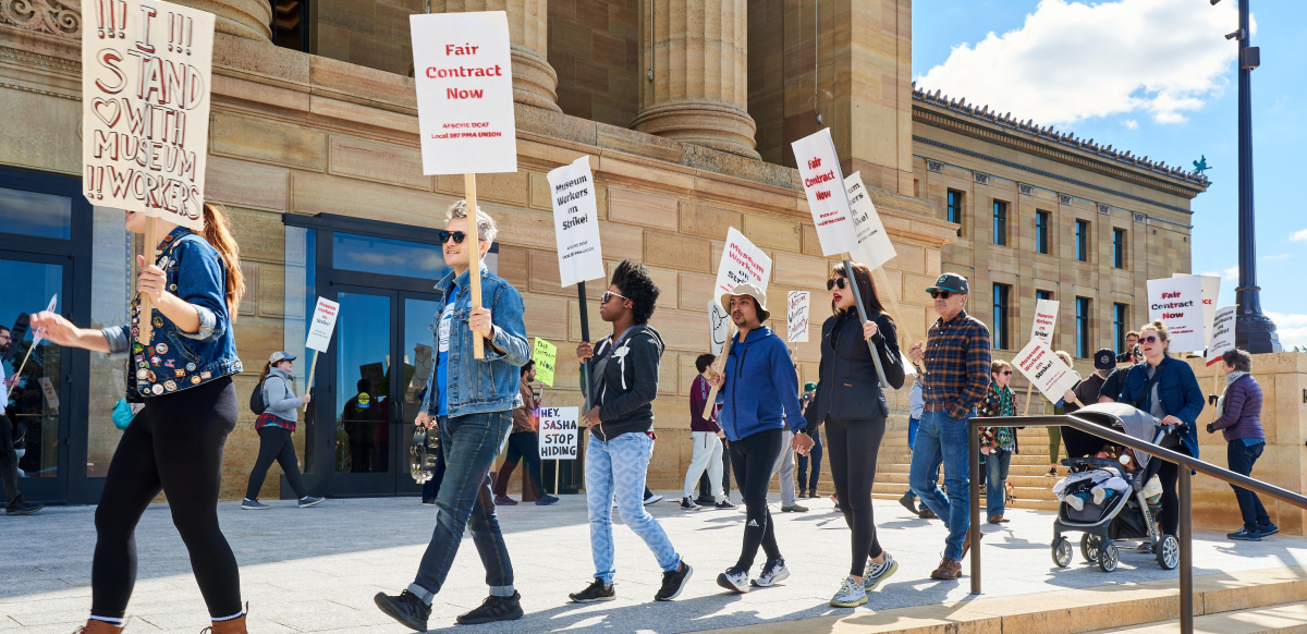 Strikers and supporters march with picket signs in front of the Philadelphia Museum of Art.