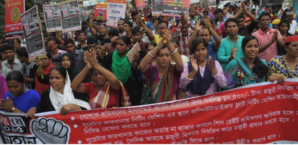 Bangladeshi workers rally behind a banner