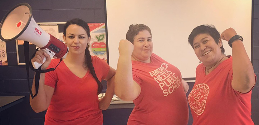 Three Chicago teachers, one with bullhorn and two with arms flexed.