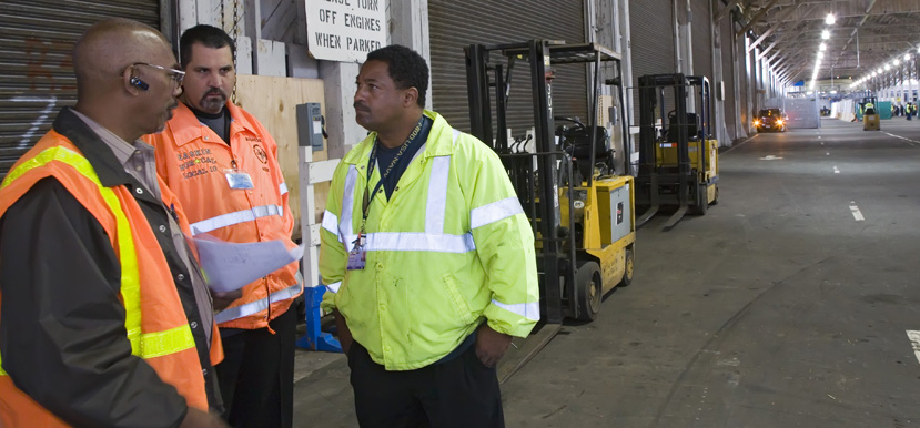 Three workers discussing workplace issues.