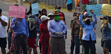 Group of protesters in Honduras assembled in the street with signs