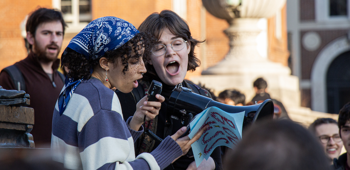 two young people address a crowd in what appears to be a campus setting